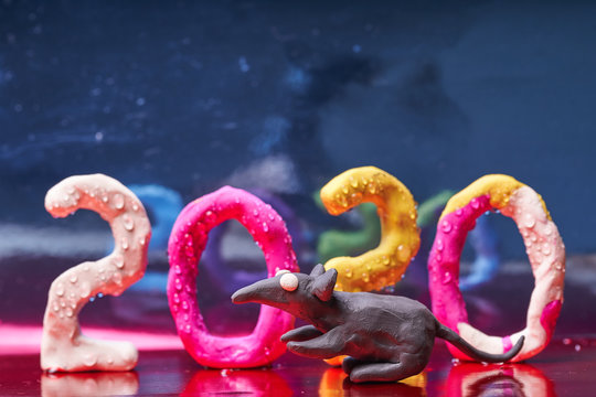 2020 New year design concept with the symbol of the year rat. Colored figures of plasticine on a blue background