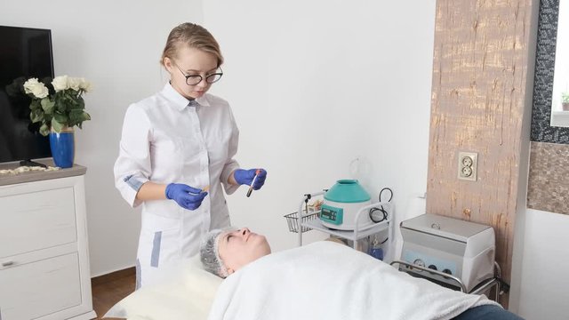 Young female cosmetologist consults patient before mesotherapy procedure