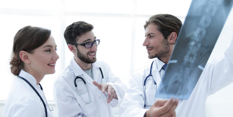 Fototapeta premium Three confident doctors examine an x-ray
