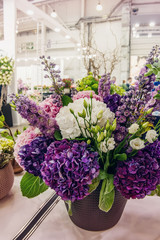 Bouquet of beautiful purple and white hydrangeas with eustoma flowers and colorful inflorescences Delphinium . Modern trends in floriculture. decoration of residential premises with flowers