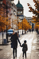 Mother and baby are walking around the city. Mom and son walk in autumn St. Petersburg