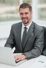 Fototapeta na wymiar closeup.smiling businessman working with laptop