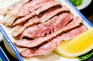 Sliced grilled Strip Loin rare degree of ripeness beef steak served.
