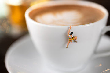 Miniature people : Coffee cup , image use for charge your energy in the morning