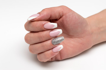 Nails Manicure 2019. Design. Wedding sharp French manicure with silver sequins on the ring fingers on a white background close-up on long nails