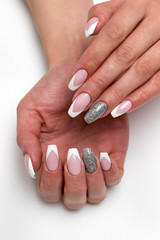 Nails Manicure 2019. Design. Wedding sharp French manicure with silver sequins on the ring fingers on a white background close-up on long nails