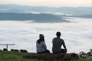Fototapeta premium silhouette of man and woman in the morning.And morning mist on the hilltop of Nan province, Thailand.
