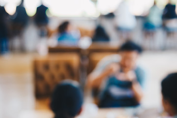 Abstract blurred people sitting in cafe with drink