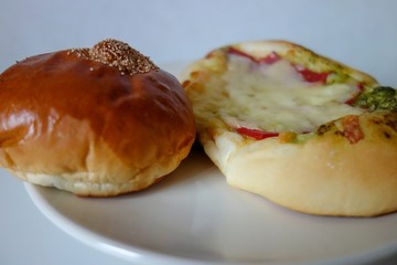 皿の上のアンパンとチーズパン