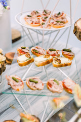 Delicious canapes as event wedding dish. Catering - served table with various snacks, canape and appetizers. Selective focus