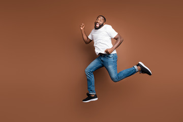 Fototapeta na wymiar Full length body size view of his he nice attractive cheerful cheery funky childish bearded guy jumping having fun running fooling isolated on dark red brown pastel color background