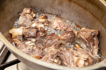 Lamb meat is fried in a pan