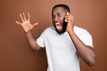 Close-up portrait of his he nice attractive fury aggressive mad evil bearded guy wearing white tshirt talking on phone having conflict quarrel fight isolated on dark red brown pastel color background