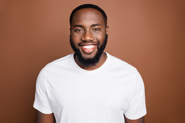 Close-up portrait of his he attractive content cheerful cheery bearded guy wearing white tshirt isolated over dark brown platinum pastel color background
