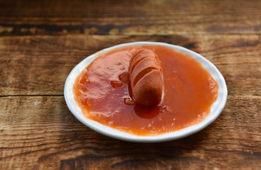 hot sausages with cuts in tomato sauce