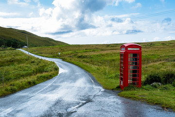 Rote Telefonzelle neben einer Landstraße auf der Isle auf Skye in den schottischen Highlands