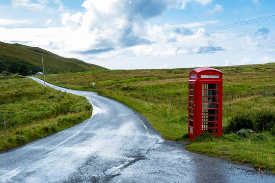 Rote Telefonzelle neben einer Landstra&szlig;e auf der Isle auf Skye in den schottischen Highlands