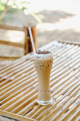 Ice cappuccino coffee on wooden table background.