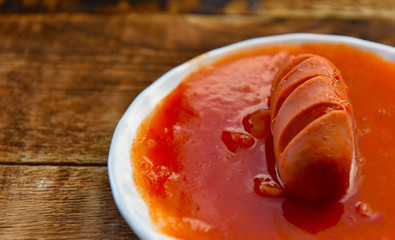 hot sausages with cuts in tomato sauce