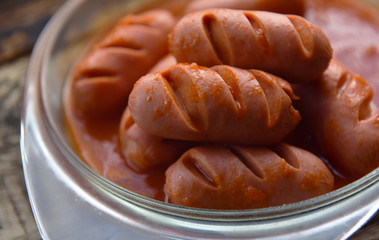 hot sausages with cuts in tomato sauce