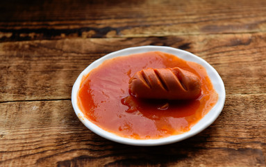 hot sausages with cuts in tomato sauce