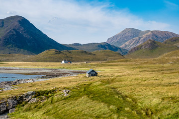 Einsame Hütten in einer Bucht der isle of Skye mit Bergen im Hintergrund