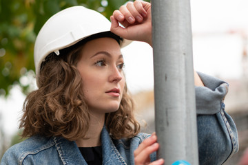 Close up portrait of a pensive and contemplative factory female employee wearing a white protective...