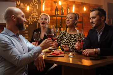 Group of friends having fun talk behind bar counter in a cafe
