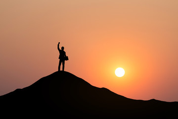 Silhouette of businessman raising his hand to celebrate success on top of mountain, White background.