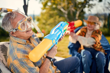 Senior couple   playing with water gun