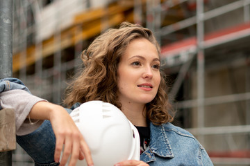 Work break on construction site: thoughtful and contemplative factory female employee resting