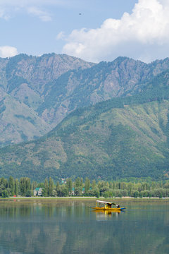 Kashmiri man paddling a shikara (traditional boat) on Dal Lake of Kashmir, India. Since 1947 the ownership of Kashmir has been disputed between Pakistan and India.