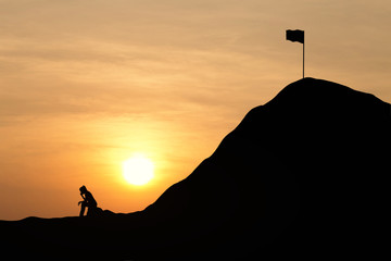 Silhouette woman are sad to not be able to climb the mountain. Sky and sunset background. Unsuccessful and fail concept.