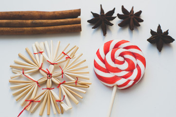 lollipop, cinnamon and Christmas decorations on white background