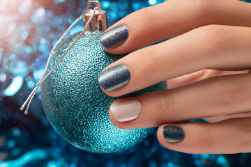 Beautiful female hand with blue christmas nail design
