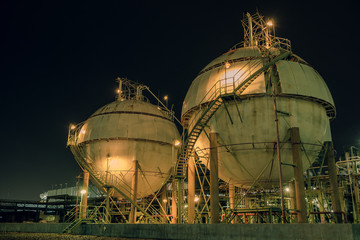 Gas storage sphere tank in gas and oil refinery plant at night, Close up of equipment in petrochemical plant