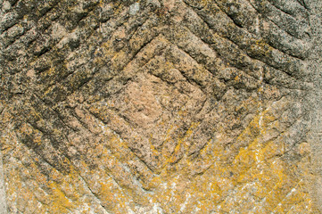Old weathered mossy sandstone surface with lichens closeup as stone background