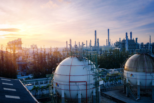 Gas storage sphere tanks in oil and gas refinery plant with sunset sky background