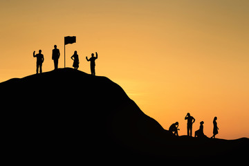 Silhouette of successful team and team that failed at sunset background.