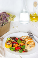 Grilled chicken with grilled vegetables on a wooden background. Healthy eating.