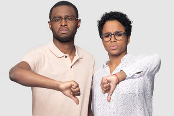 Head shot unhappy African American couple showing thumbs down