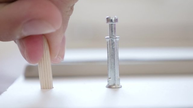 Wooden dowel pin putting into drilled hole in drawer 1080p slow motion footage
