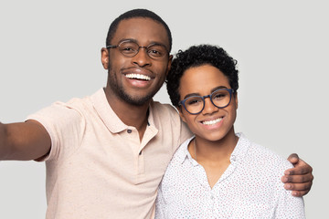 Head shot happy African American couple in glasses taking selfie
