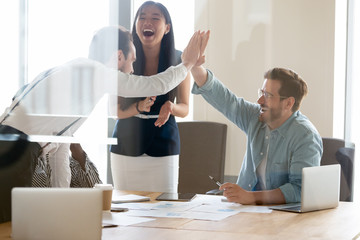 Business people giving high five, excited colleagues celebrating success