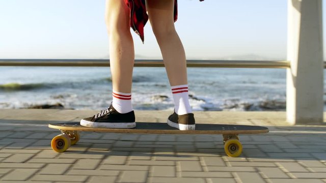 Carefree holiday active lifestyle longboard skateboarding along the ocean