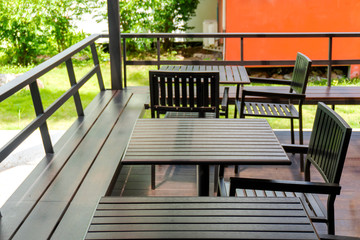 Obraz na płótnie Canvas Oak color table and chairs are located on the terrace outside of the building, for guests to relax or eat