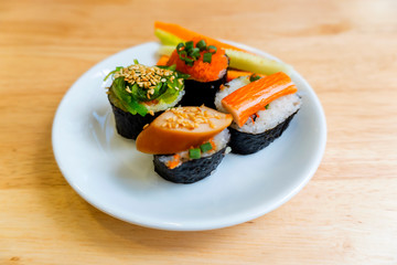 Rice Sushi is a lump of meat on white plate put on wood table  and eaten with sauce in Japanese food restaurant is a popular dish in Thailand