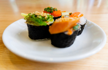 Rice Sushi is a lump of meat on white plate put on wood table  and eaten with sauce in Japanese food restaurant is a popular dish in Thailand