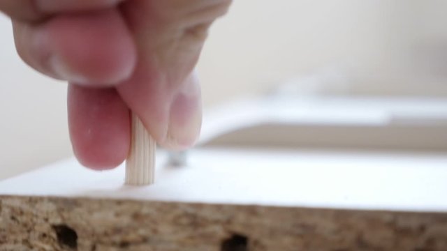 Wooden dowel pin inserting into drilled hole 1080p slow motion video