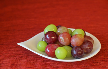 Some grapes and muscats on white dish